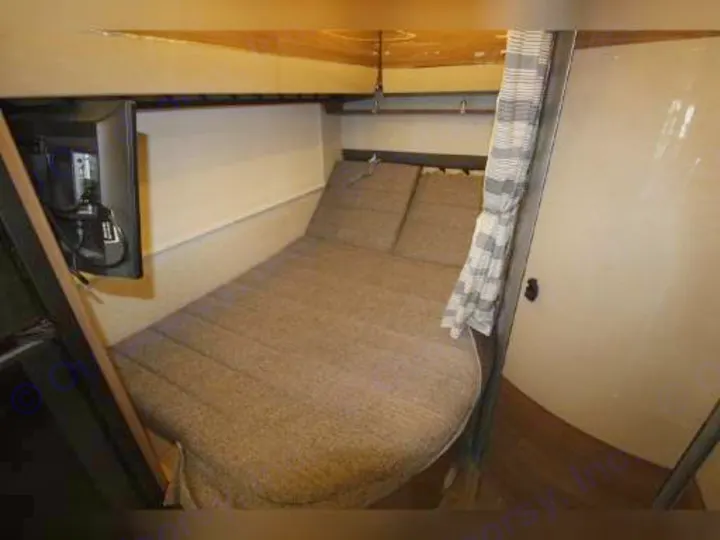 Experience comfort in this RV rental bedroom featuring a wall-mounted TV and a soft, patterned bed.. Winnebago View 2018
