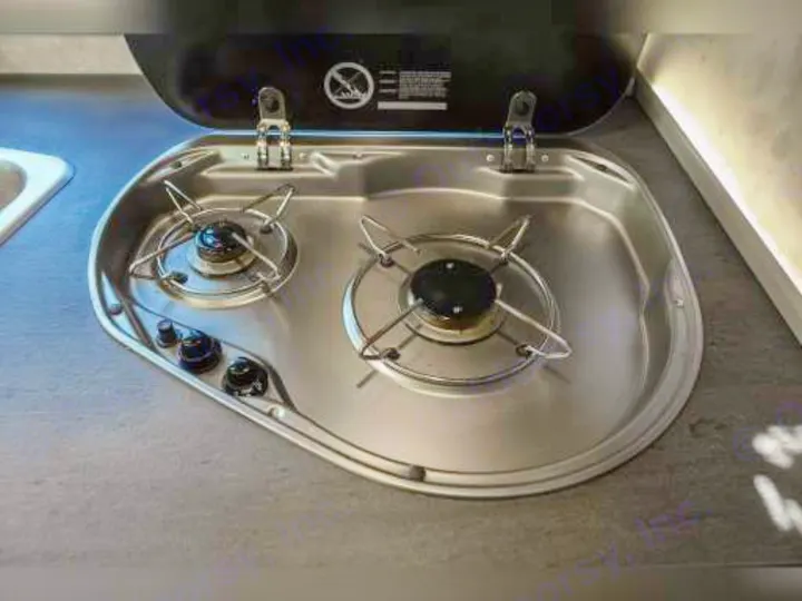 Inside an RV rental: A compact stainless steel two-burner stove with control knobs and a sink, ideal for travel cooking.. Winnebago View 2018