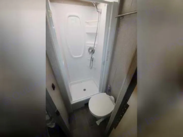 RV rental's compact bathroom: Features a white, space-saving corner shower and toilet. Ready for your travel comfort.. Winnebago View 2019