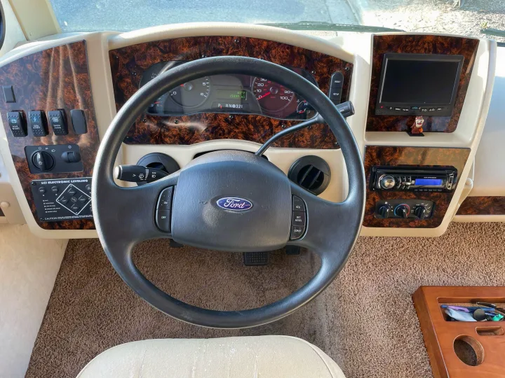 Inside an RV rental: driver's view of the dashboard, steering wheel, and essential controls for. Coachmen Mirada 2014