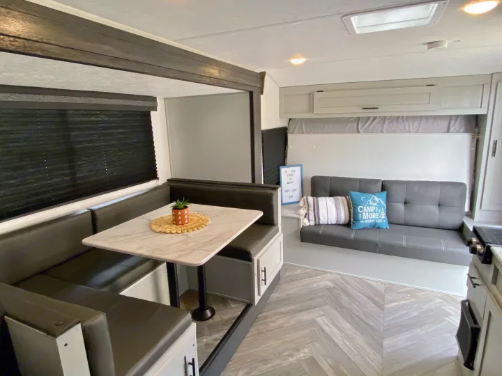 RV rental: A stylish interior with a practical dinette, cozy sofa, and compact kitchen for comfortable travel.. Forest River Wildwood 2021