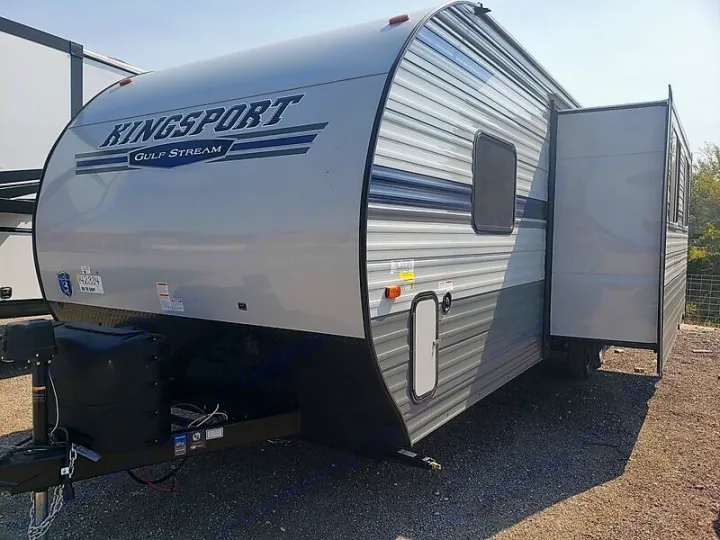 Front view of a light grey Kingsport Gulf Stream travel trailer RV, with extended slide-out, ready for rv rental.. Gulf Stream Kingsport 2021