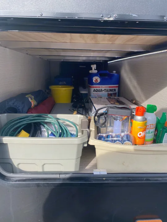 Spacious and organized RV rental storage, featuring camping essentials: water container, hoses, and bug repellent.. Cruiser Rv Corp Fun Finder 2018