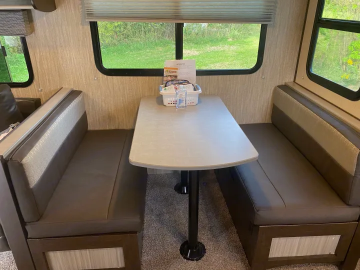 Experience comfort in this RV rental's dinette area, featuring booth seating, a table with essentials, & scenic windows.. Cruiser Rv Corp Fun Finder 2018