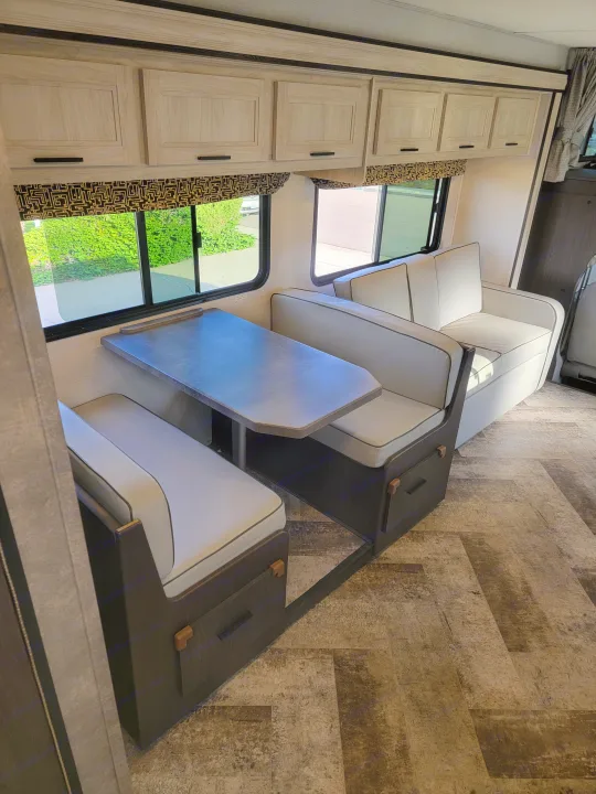 RV rental: Modern dinette with light wood cabinets, comfortable seating, and a view outside.. Forest River Sunseeker 2021