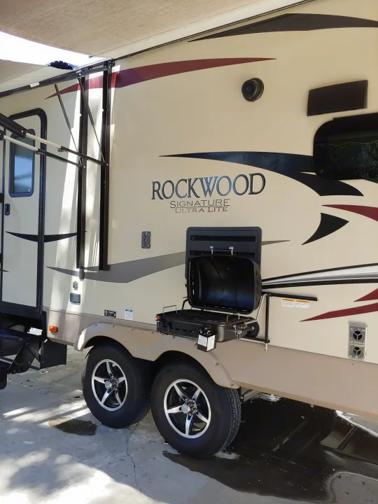 RV rental: A tan travel trailer with an extended awning and a side-mounted grill.. Forest River Rockwood Signature Ultra Lite 2017