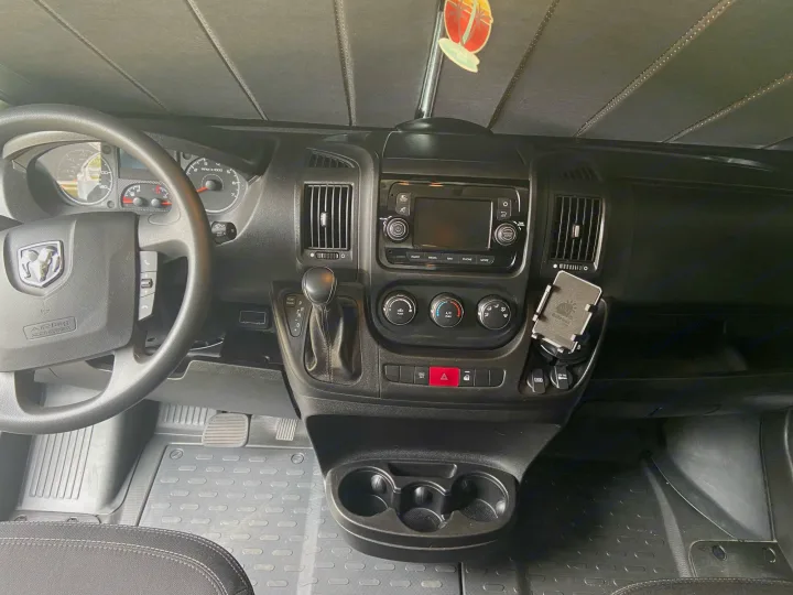 RV rental interior from driver's seat, showing dashboard, steering wheel, media system, and climate controls.. Winnebago Solis 2021