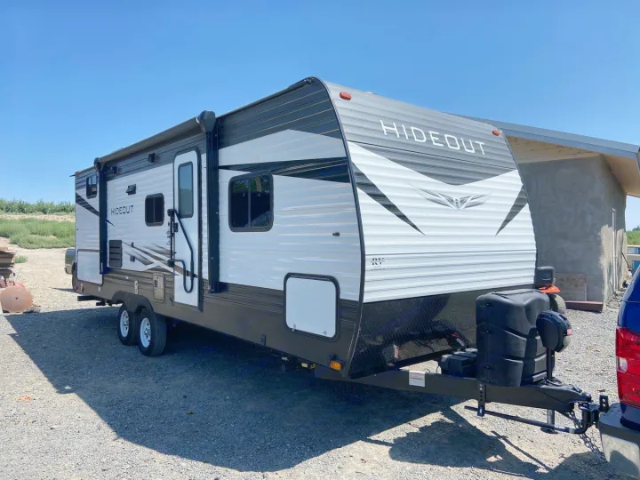 A sleek white and gray Hideout travel trailer, perfect for your next RV rental and outdoor camping adventure.. Keystone Hideout 2021