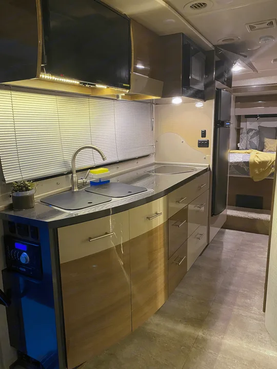 Sleek RV rental interior with a well-equipped kitchenette, entertainment system, and comfortable sleeping area.. Winnebago View 2016