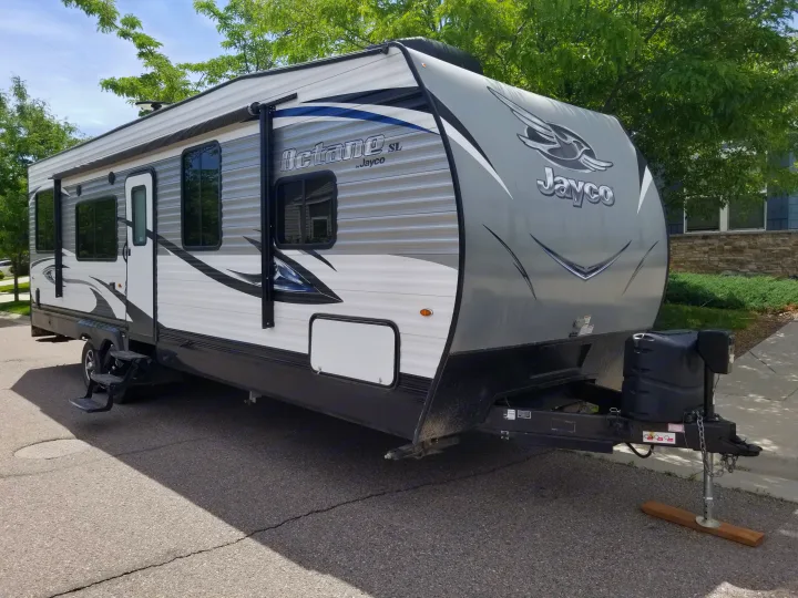 A large grey and white Jayco Octane SL travel trailer, an excellent RV rental for your next outdoor adventure.. Jayco Octane 2017