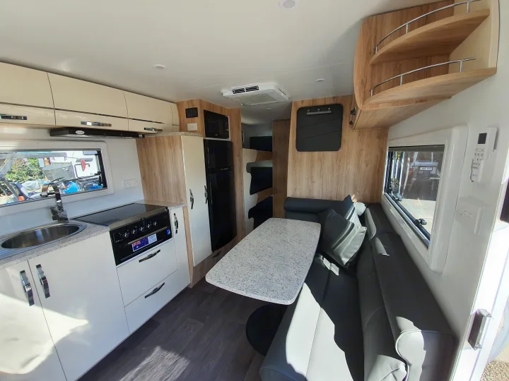 Modern RV rental interior with full kitchen, dining area, lounge, and bunk beds, offering spacious comfort.. Avan Aspire 617 Family 2021