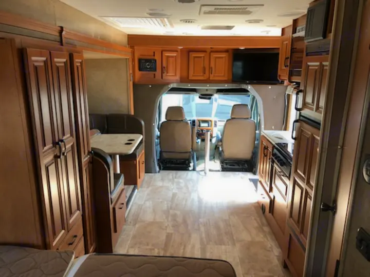 View inside a well-appointed RV rental, showing the kitchen, dinette, and front driver's area for comfortable travel.. Forest River Sunseeker 2017