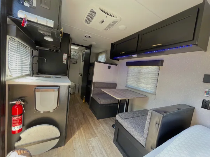 Step inside this rv rental showcasing a compact kitchen, dinette, and comfortable bed area, ideal for travel.. Forest River Cherokee Wolf Pup 2022