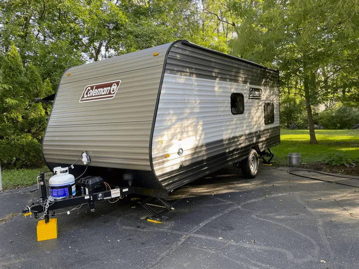 Coleman travel trailer RV rental, poised on an asphalt driveway for your next camping adventure.. Coleman Other 2022