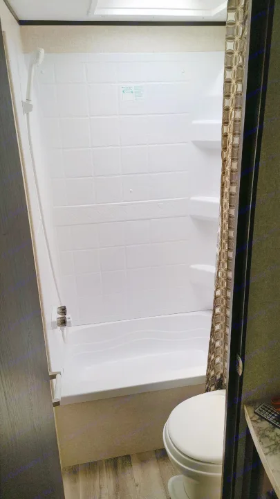 This RV rental bathroom features a functional white shower stall with a textured wall, shower head, and toilet.. Jayco Jay Flight 2019