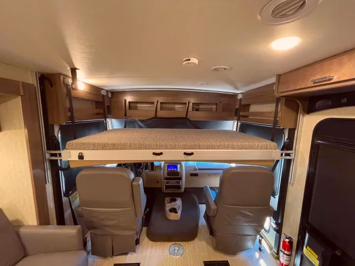 This RV rental features a cozy, lowered bunk bed over the driver and passenger cockpit area, ready for adventure.. Winnebago Adventurer 2022