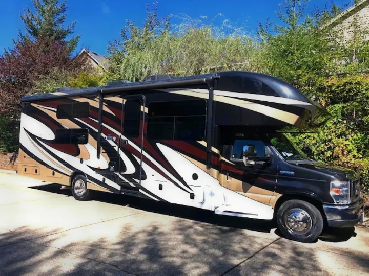 Spacious Class C RV rental. Black, brown, & white motorhome parked on a sunny day, ready for adventure.. Jayco Greyhawk 2018