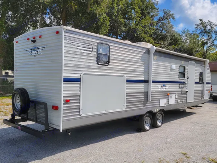 Spacious silver Shasta travel trailer, equipped with a rear spare tire and cargo rack, available for rv rental.. Other Other 2021