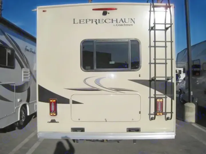 Rear view of an RV rental, a beige Coachmen Leprechaun, featuring a ladder, window, and storage. Ideal for travel.. Coachmen Leprechaun 2021