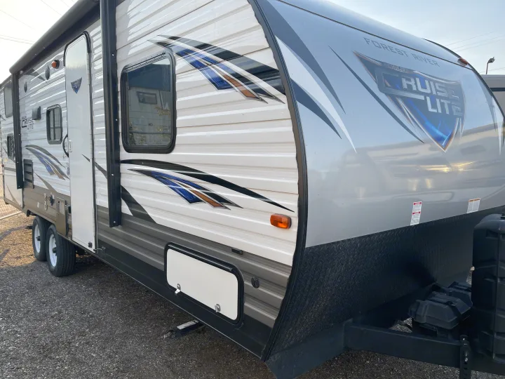 Forest River Cruise Lite travel trailer RV rental. Exterior shows white/gray siding, blue/brown graphics, windows, and door.. Forest River Cruise Lite 2019