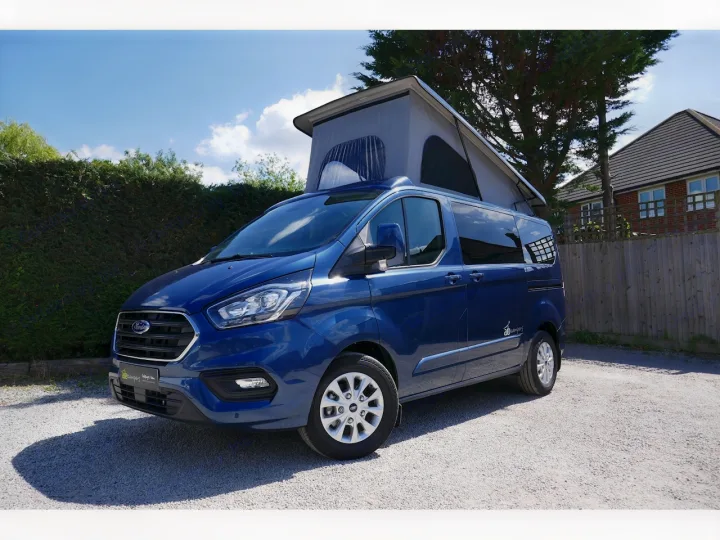 A blue Ford Transit Custom pop-top campervan, perfect for your next rv rental adventure, parked on a sunny day.. Ford Transit Custom 2+2 berth Pop Top, Manual 2022
