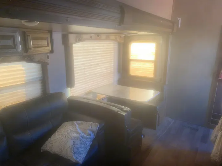 Bright RV rental interior showcasing a comfortable sofa, full dinette area, and sunny windows with blinds.. Keystone Cougar 2017