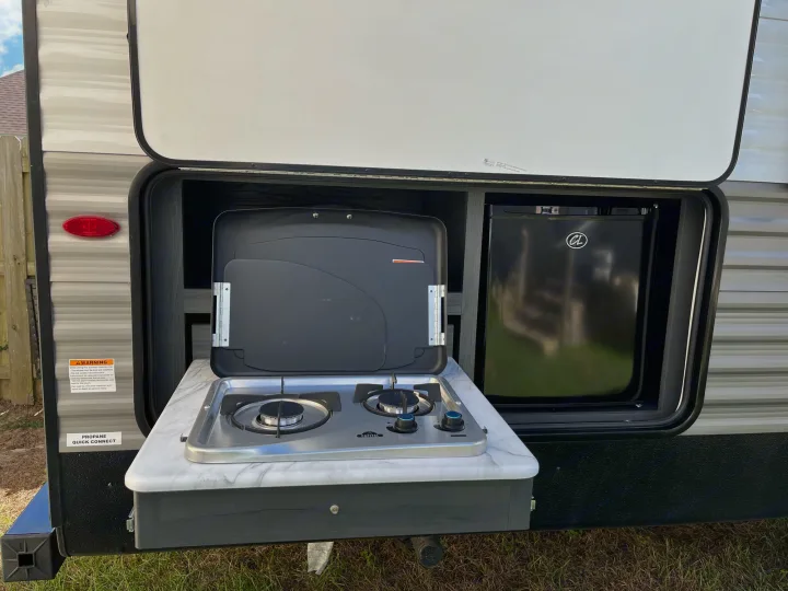 Enjoy this RV rental's pull-out outdoor kitchen with a built-in stove, mini-fridge, and countertop for easy outdoor cooking.. Dutchmen Aspen Trail 2021