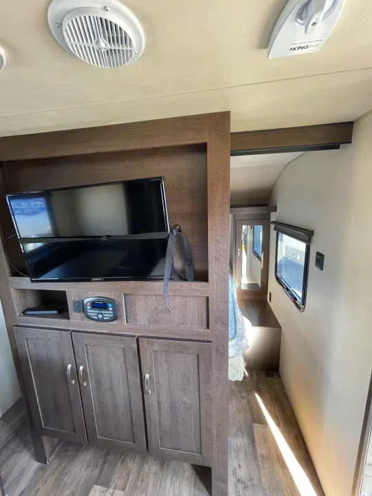 RV rental interior: A modern living space with TV, entertainment system, storage, and a glimpse into the bedroom.. Forest River Cruise Lite 2019