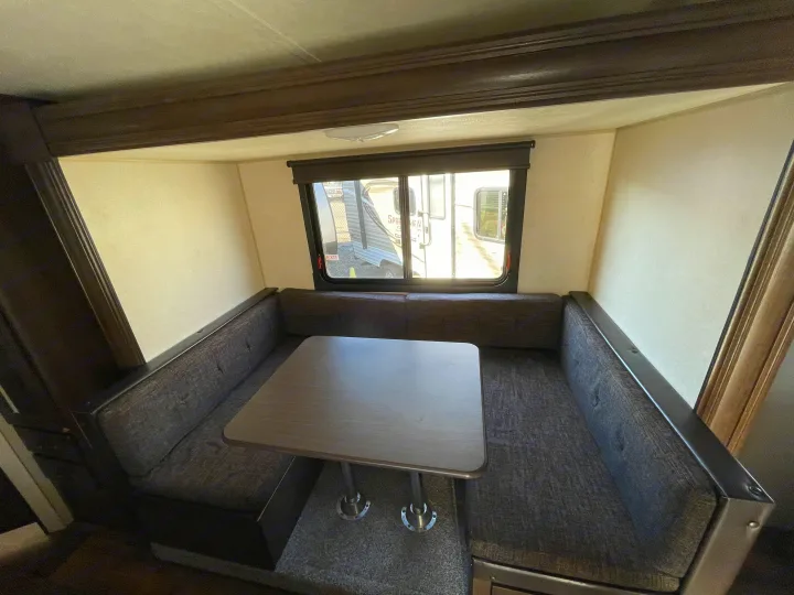 U-shaped dinette seating and table in an RV rental, perfect for meals and lounging in your camper.. Forest River Cruise Lite 2019