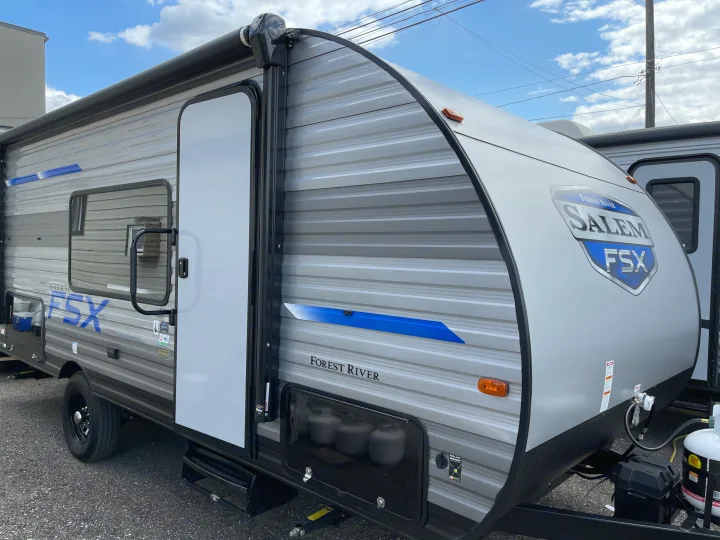 Forest River Salem FSX travel trailer exterior, featuring an awning, door, and propane tanks, ideal for your next rv rental.. Forest River Salem 179 2021