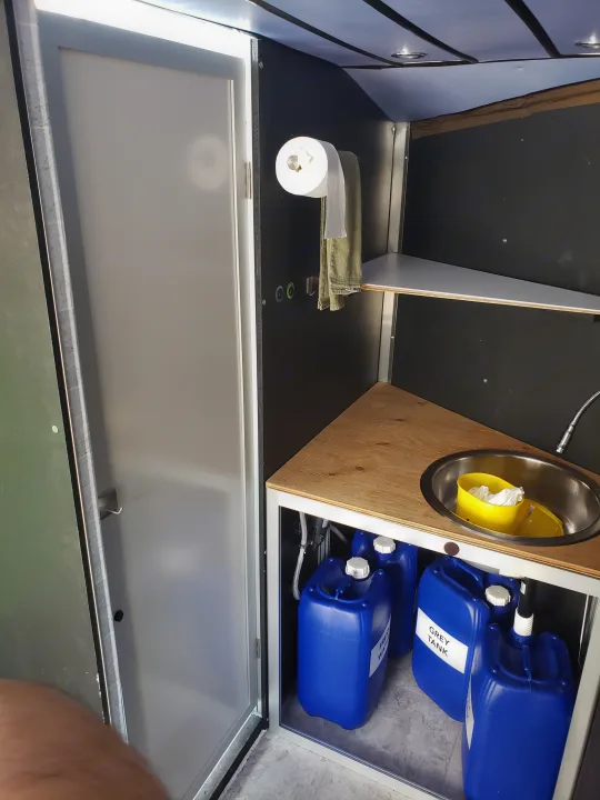 Functional rv rental utility area: compact sink, fresh/grey water tanks, and toilet paper for convenience.. Neo Trailer NAV105S 2020