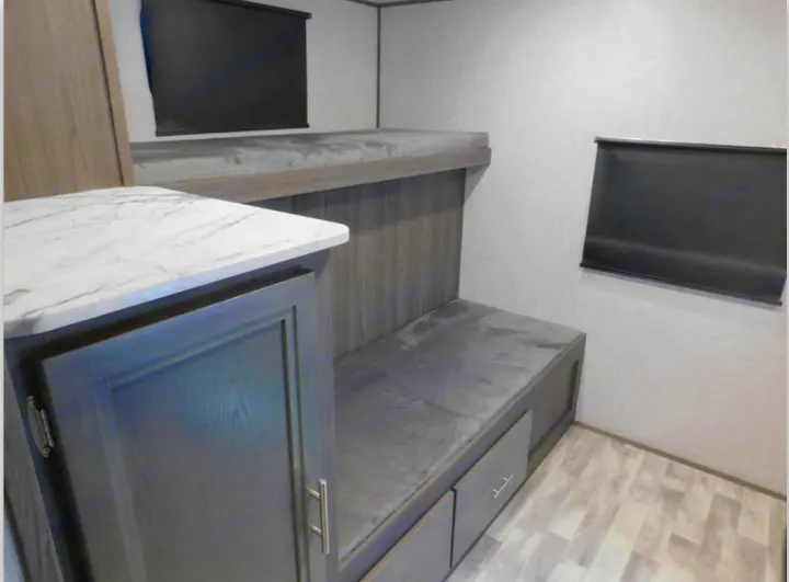 RV rental bunk room with dual beds, ample storage drawers, and a built-in counter/cabinet. Ideal for family adventures.. Dutchmen Other 2021