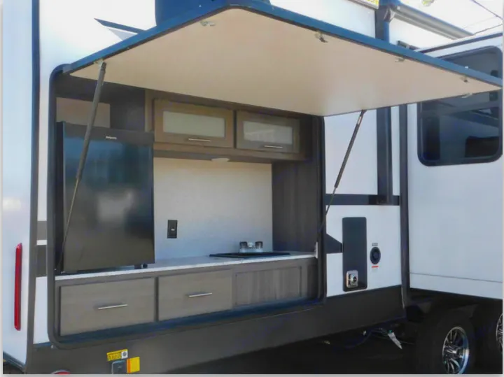 This RV rental boasts a convenient outdoor kitchen, complete with a mini-fridge, sink, and ample counter space for your camping adventures.. Dutchmen Other 2021