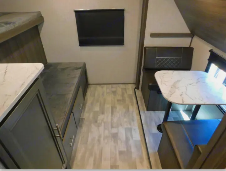 Explore the comfortable rv rental interior: a cozy bunk bed, functional kitchen counter, and spacious dinette with table.. Dutchmen Other 2021