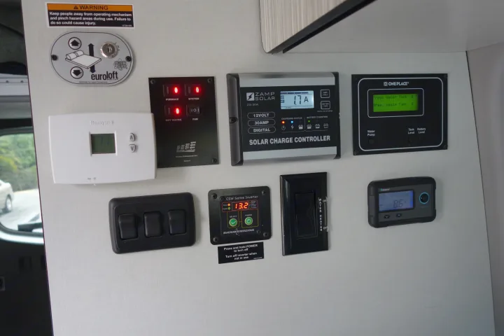RV rental control panel displaying solar charge, water/tank levels, inverter, thermostat, and other system controls.. Winnebago Revel 2019