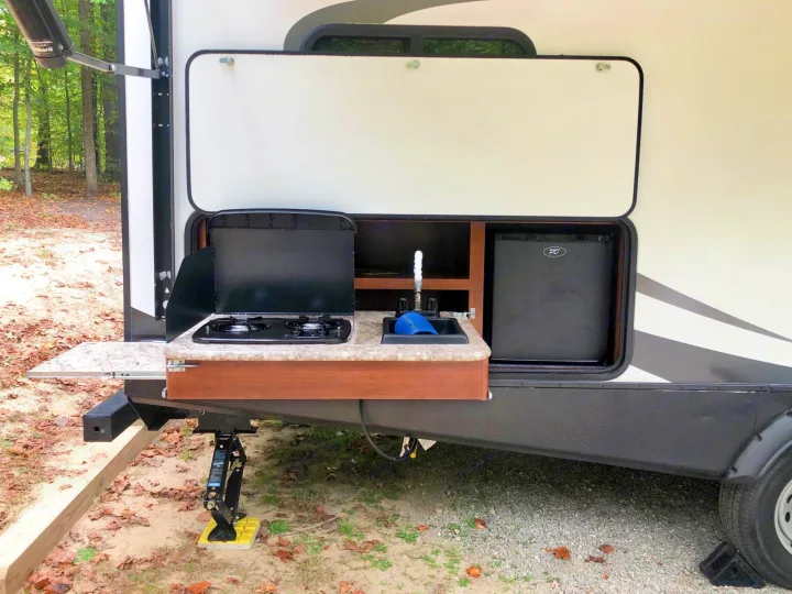 This RV rental features a convenient outdoor kitchen with stove, sink, and fridge for camping adventures.. Keystone Passport 2017