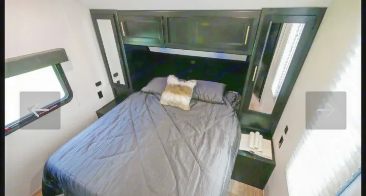Cozy modern RV rental bedroom interior featuring a comfortable bed, overhead storage, and windows, ideal for travel.. Forest River Cherokee Grey Wolf 2021