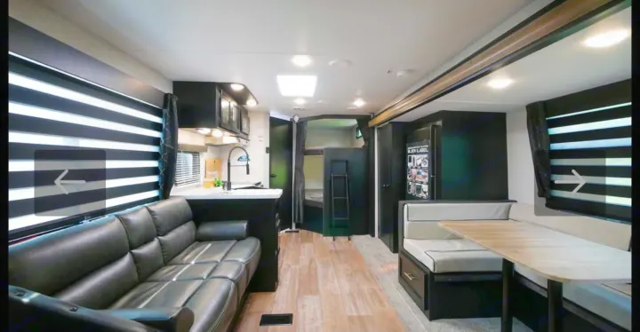 Spacious RV rental interior featuring a modern living area, kitchen, dinette, and bunk beds for comfortable travel.. Forest River Cherokee Grey Wolf 2021