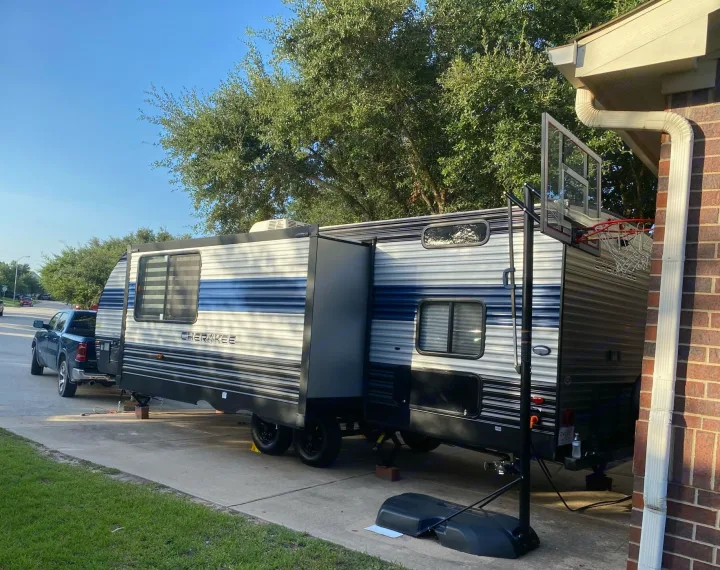 Cherokee RV rental with slide-outs extended, parked on a residential driveway, ready for adventure.. Forest River Cherokee Grey Wolf 2021