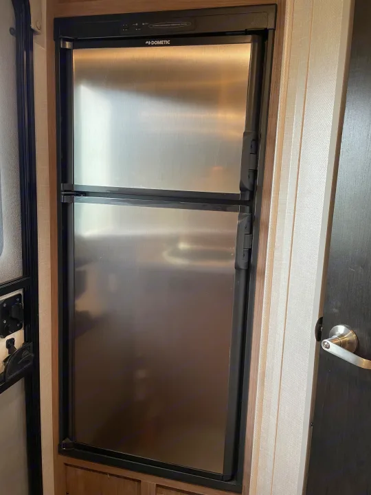 Dometic stainless steel refrigerator inside an rv rental, showcasing its compact design.. Forest River R-Pod 2020