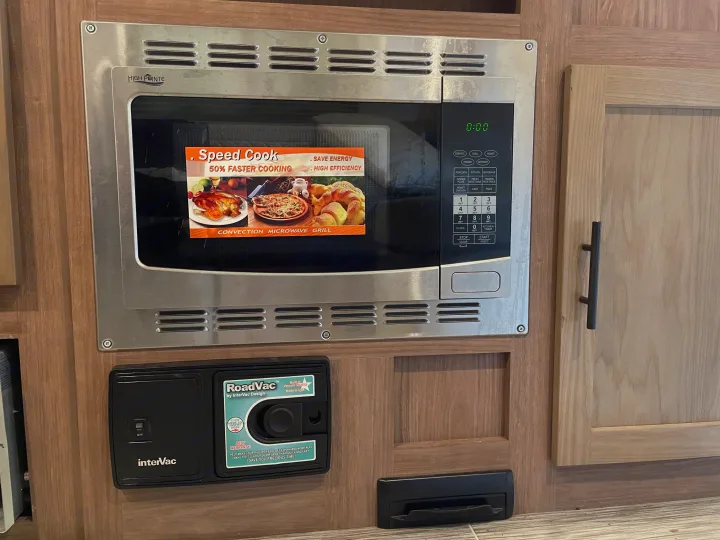 RV rental interior featuring a High Pointe convection microwave oven and an InterVac RoadVac built-in vacuum system.. Forest River R-Pod 2020