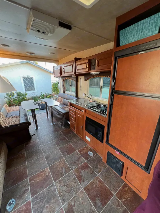 This inviting RV rental interior features a functional kitchen with stove and microwave, a comfortable dinette, and ample living space.. Forest River Stealth 2012