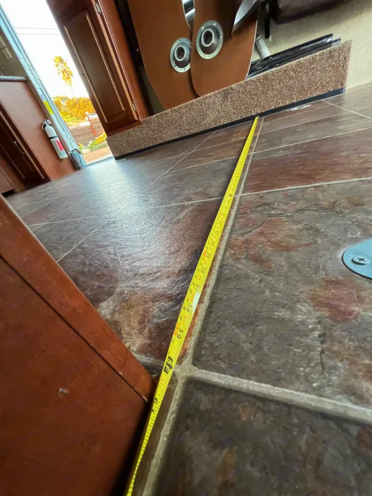 A tape measure spans the RV rental floor, indicating over 5 feet of interior space.. Forest River Stealth 2012