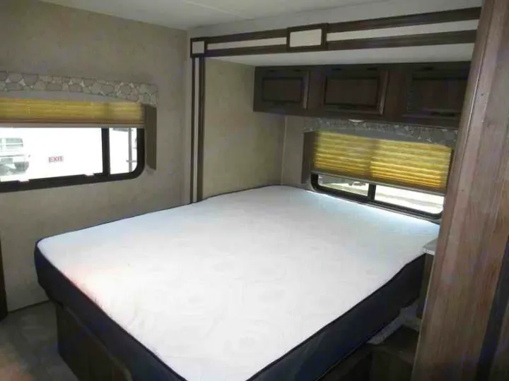 RV rental bedroom: a comfortable mattress, windows with blinds, and ample overhead storage for your travels.. Coachmen Freelander 2019