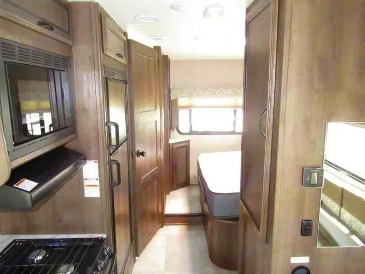 Efficient RV rental interior showcasing a compact kitchen, comfortable bedroom, and living space with modern finishes.. Coachmen Freelander 2019