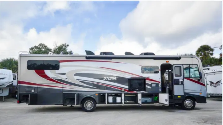 Get away in this sleek motorhome rv rental, showing open compartments for gear and an outdoor entertainment setup.. Fleetwood Other 2017