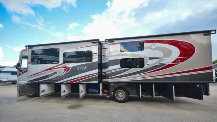 Side view of a large, modern RV rental with open external storage compartments, ready for your travels and camping adventures.. Fleetwood Other 2017