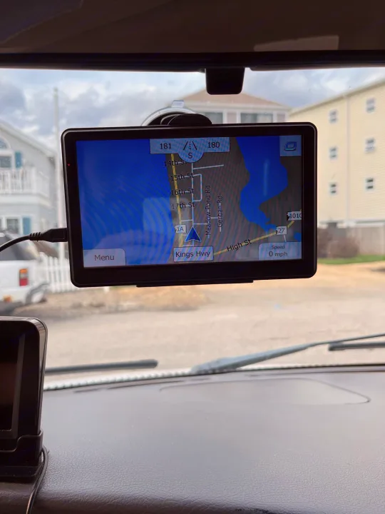 Inside an RV rental, a GPS navigation device displays a map with streets like Kings Hwy, showing 0 mph speed, ready for travel.. Ford Econoline E250supercab 1999