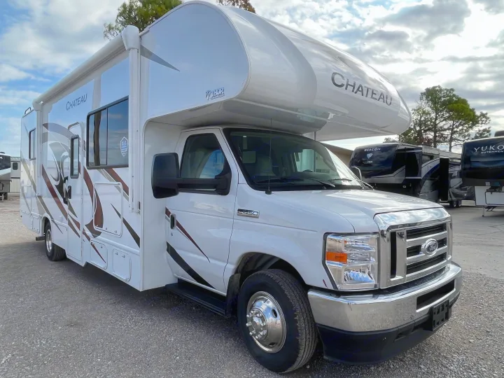 White Thor Chateau Class C RV rental, built on a Ford E-450 chassis, parked on a gravel lot under a cloudy sky.. Thor Motor Coach Chateau 2022