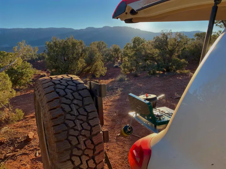 RV rental tailgate cooking: A portable stove heats a pot with stunning desert mountain views. Perfect camp kitchen setup.. Toyota Land Cruiser 2016